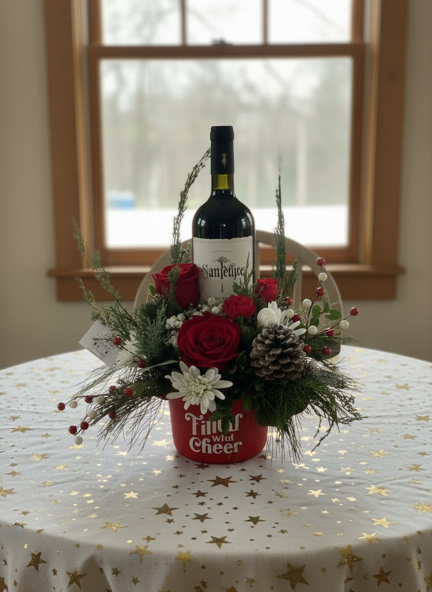 Bottle of wine in a decorative arrangement with flowers and pinecones on a concrete surface